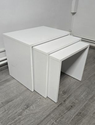 three white tables stacked on top of each other on a wooden floor