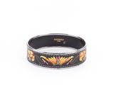 un bracelet noir orné de fleurs et de feuilles