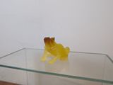 une petite grenouille jaune assise sur une table en verre
