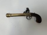 an old brass revolver with a wooden handle on a white surface
