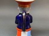 a blue vase with a red hat on top of it