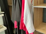 three shirts hanging on a clothes rack in a room