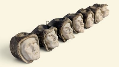 une longue rangée de têtes en pierre ornées de visages