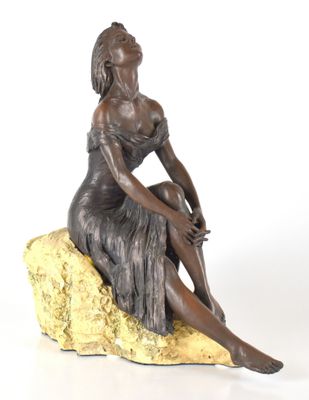 statue en bronze représentant une femme assise sur un rocher, sur fond blanc