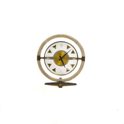 a clock that is sitting on a stand on a white surface