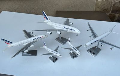 cinq maquettes d'avions posées sur une table blanche
