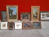 a lot of framed pictures on the ground next to a red wall
