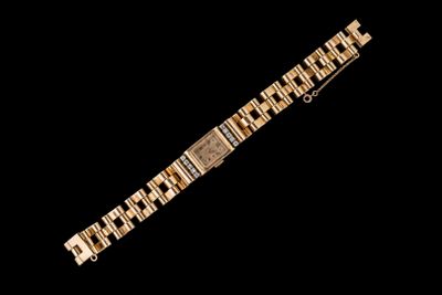 gros plan d'un bracelet en or sur fond noir