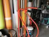 a red hand truck that is next to a stack of surfboards