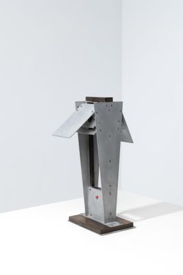 une sculpture métallique représentant un oiseau, posée sur un socle