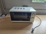 un micro-ondes posé sur une table près d'une fenêtre