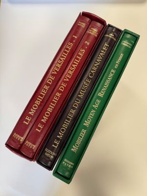 trois livres sont empilés sur une table