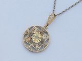 un gros plan d'un pendentif en diamant jaune monté sur une chaîne