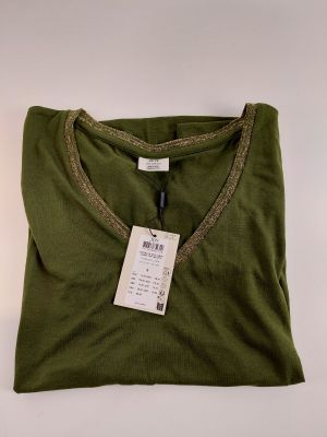 a green t - shirt with a tag on it sitting on a white surface