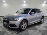 un SUV Audi argenté garé sur un sol à damier dans un showroom