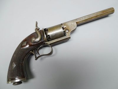 gros plan d'un pistolet sur une table à fond blanc