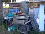 un tas de vieilleries devant un mur de pierre