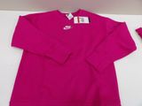a pink shirt with a tag on it sitting on a table