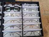 many pairs of glasses in a case on the floor