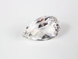 un gros plan d'un diamant transparent sur une surface blanche