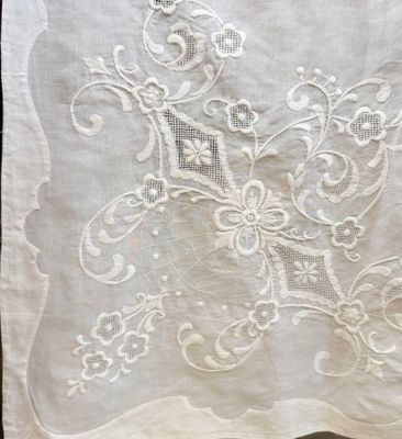 a close up of a piece of white linen with embroidery on it