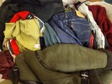 a pile of clothes in a suitcase on the floor