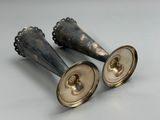 two silver candlesticks sitting next to each other on a table