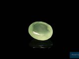 un gros plan d'une pierre de jade verte sur une surface noire