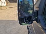 a side view mirror of a car with a reflection of a building in the side mirror