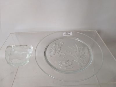 une assiette en verre et un bol en verre posés sur une table