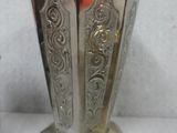 a silver vase on display with a price tag on it