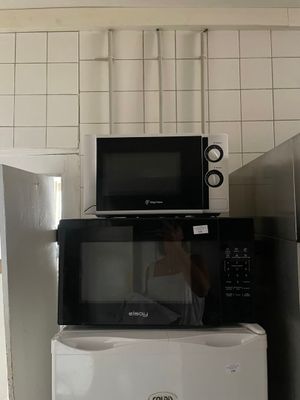 deux micro-ondes et un réfrigérateur dans une petite cuisine