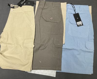 three pairs of men ' s cargo shorts with tags on them