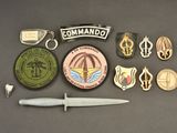 a lot of military badges and a knife on a table