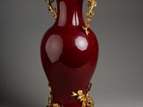 a large red vase with gold decoration on it