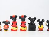 mickey mouse figurines are lined up in a row on a white surface