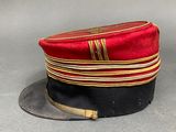 two red and black hats are sitting on a gray surface