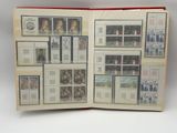 an open book with stamps on it on a white surface