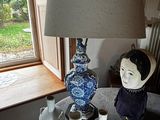 une table sur laquelle se trouvent une lampe, des vases et une figurine