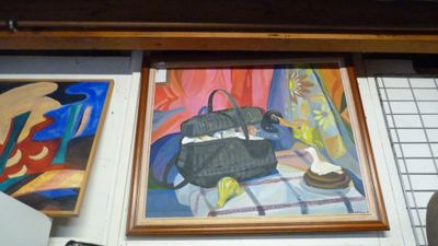 une photo représentant un tableau et un sac à main accrochés au mur