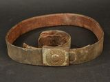 une vieille ceinture avec une boucle métallique sur un fond noir