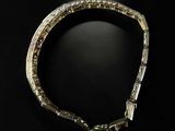 a close up of a diamond bracelet on a black surface