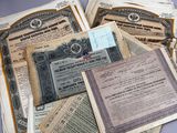 plusieurs anciens certificats papier sont empilés les uns sur les autres
