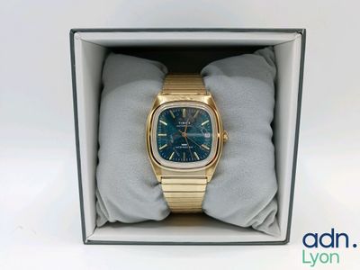 une photo d'une montre en or à cadran bleu dans un coffret