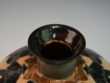 a vase that has a black and yellow design on it