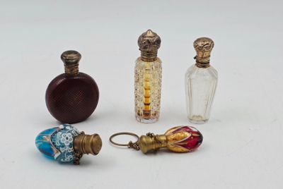 quatre petites bouteilles en verre sont alignées sur une surface blanche