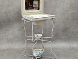 a small table with a mirror on it and a cup on it
