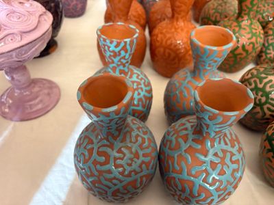 de nombreux vases de différentes couleurs, tous ensemble sur la table