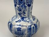 a blue and white vase sitting on a white surface