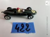 une petite voiture noire surmontée d'un chapeau rouge
